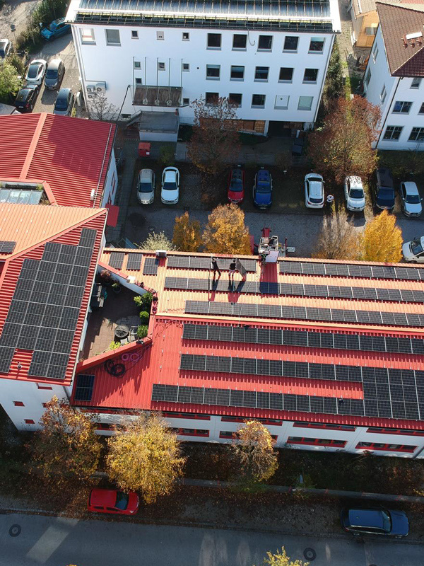 Drohnenaufnahme einer großen Photovoltaik-Anlage auf einem roten Gewerbedach im Landkreis Landshut